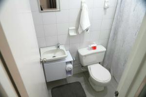 a small bathroom with a toilet and a sink at Ideal para trabajar y descansar in Cali +2 photos