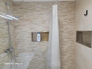 a bathroom with a shower with a bottle of soap at Grande apartamento a 14 km de Lisboa in Laranjeira +20 photos