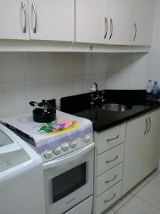 a kitchen with a stove with a pot on top of it at Apartamento Solar do Centro - Gramado RS in Gramado