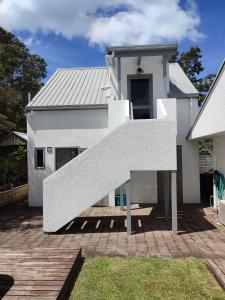 une maison blanche avec un escalier en face de celle-ci dans l'établissement Luxurious studio room, à Whitianga 4 autres photos