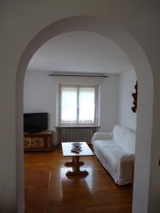 salon z białą kanapą i stołem w obiekcie Appartamento Sole w mieście Borca di Cadore