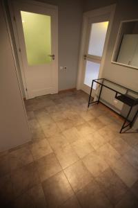 ein leeres Zimmer mit einem Glastisch auf einem Fliesenboden in der Unterkunft Apartament Prusa in Bad Salzbrunn