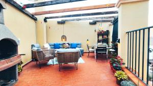 a patio with a couch and chairs and a table at La Terraza de La Línea in La Línea de la Concepción
