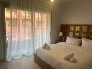a bedroom with a bed and a large window at Bel Appartement meublé avec Piscine, l'hivernage à Marrakech in Marrakech +16 photos
