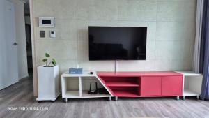 a living room with a red desk and a tv at Busan Suwol in Busan