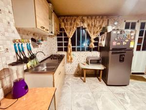 a kitchen with a refrigerator and a counter top at Hospedaje Rural Villa Sadais in Monguí