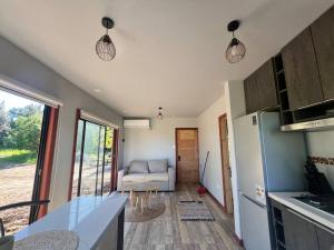 a kitchen and a living room with a couch at Cabaña de campo pequeña in Los Ángeles