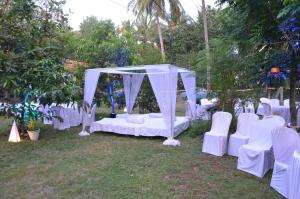 a wedding altar with white chairs and a canopy at Raikar Guest House in Bogmalo