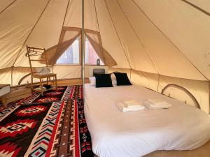 a large bed in a tent with towels on it at The hi Ocean resort เดอะไฮโอเชี่ยนรีสอร์ต in Khlong Yai