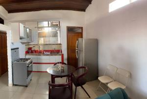 a kitchen with a table and a stainless steel refrigerator at Apartamento Estancia Tropical in Pucallpa