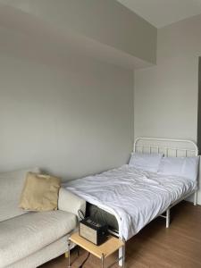 Bett in einem Zimmer neben einer Couch in der Unterkunft Condo unit in The Loop Limketkai CDO in Cagayan de Oro