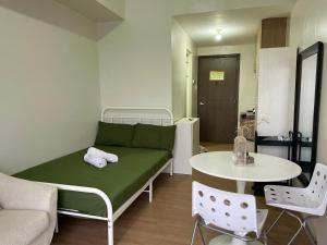 ein Wohnzimmer mit einer grünen Couch und einem Tisch in der Unterkunft Condo unit in The Loop Limketkai CDO in Cagayan de Oro