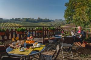 kobieta siedząca na patio ze stołami i krzesłami w obiekcie Locanda Camera con Vista w mieście Faenza