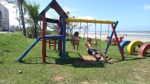 a group of children playing on a playground at the beach at Pousada Amarela Beach in Itanhaém +1 photo