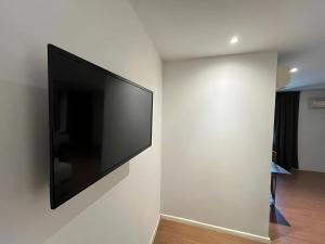 a flat screen tv hanging on a white wall at Sky Hotel Cheras Maluri in Kuala Lumpur