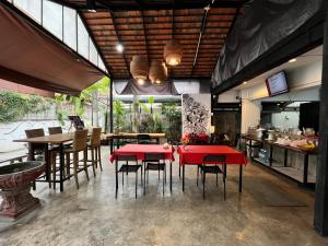 a dining room with red tables and chairs at RCN Court & Inn in Chiang Mai