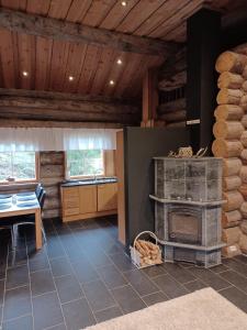 a living room with a fireplace and a table at Rukan Villa Nuotta in Ruka