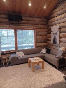 a living room with a couch and a table at Rukan Villa Nuotta in Ruka
