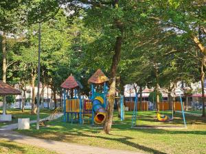 a playground with a slide in a park at Cozy Sunny Home BBQ Steamboat KTV Bukit Indah JB in Johor Bahru