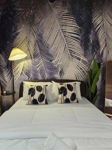 a bedroom with a white bed with pillows and a plant at Cozy Sunny Home BBQ Steamboat KTV Bukit Indah JB in Johor Bahru +85 photos