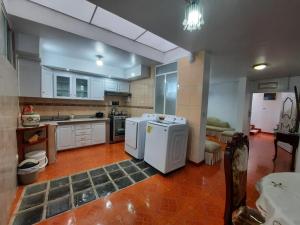 a large kitchen with white appliances in a room at Amplio departamento in Loja