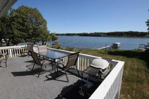 un patio con mesa y sillas junto al agua en The Foxhole on East Lake Okoboji, en Spirit Lake