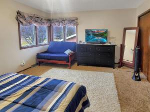 1 dormitorio con 1 cama azul, vestidor y TV en The Foxhole on East Lake Okoboji, en Spirit Lake