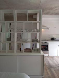 a white cabinet in a kitchen with dishes on it at Eneas Flat luminoso con cochera in Pinamar