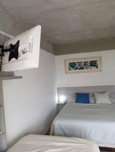 a bedroom with two beds and a ceiling at Eneas Flat luminoso con cochera in Pinamar