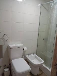 a bathroom with a toilet and a shower and a sink at Eneas Flat luminoso con cochera in Pinamar +25 photos