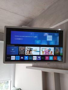 a flat screen tv sitting on top of a stand at Eneas Flat luminoso con cochera in Pinamar