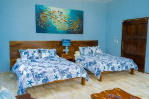 a bedroom with two beds and a blue wall at Rancho Plèyades in Metalío +142 photos
