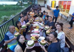 een groep mensen die aan een tafel zitten en eten bij Hadthong Resort in Ban Hat Khai Tao