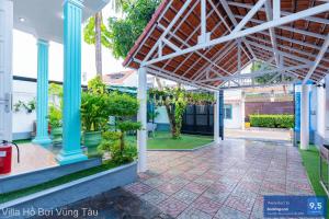 a patio of a house with blue columns and plants at Villa Sân Vườn Gần Biển Bãi Sau - Free Bida - Dàn Karaoke in Vung Tau +22 photos