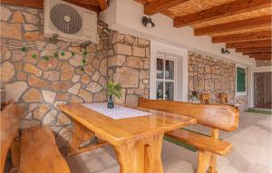 a dining room with a wooden table and a stone wall at Nice Home In Unesic With Wifi in Unešić +31 photos