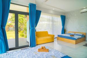 a bedroom with a yellow bed and a yellow couch at TP-HOMES PHAN THIẾT in Phan Thiet