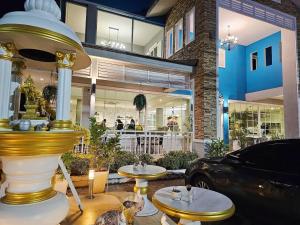 a restaurant with two tables and a fountain in front of a building at บ้านธนาบูติคโฮเทล in Suratthani