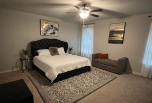 a bedroom with a bed and a couch and a ceiling fan at Toscana Villa in Round Rock