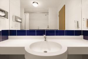 a bathroom with a white sink and a mirror at Days Inn Hotel Leicester in Leicester +17 photos