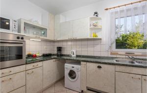 プナトにあるCozy Home In Punat With Wifiのキッチン(白いキャビネット、洗濯機、乾燥機付) +27枚の写真
