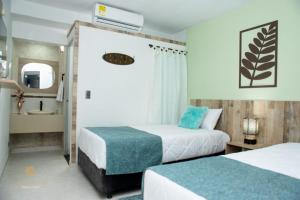 a hotel room with two beds and a bathroom at ArisSha Boutique Hotel in Cali
