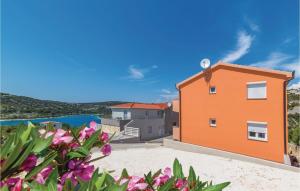 a house on the beach with flowers in the foreground at Cozy Apartment In Sevid With Wifi in Sevid