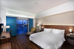una camera da letto con un grande letto bianco e una scrivania di Holiday Inn Express Villahermosa by IHG a Villahermosa