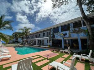 a hotel with a pool and chairs and a building at Villas VJ in Puerto Limón +12 photos