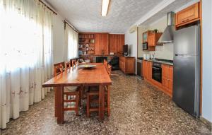 a kitchen with a wooden table and a refrigerator at Amazing Home In Deltebre With Kitchen in Deltebre