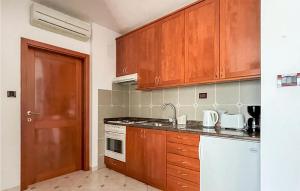 a kitchen with wooden cabinets and a stove top oven at 1 Bedroom Gorgeous Apartment In Kukci in Kukci