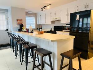 a kitchen with a counter with stools and a black refrigerator at Sherizee Home in Marblehead