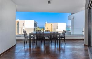 jadalnia ze stołem i krzesłami oraz dużym oknem w obiekcie 2 Bedroom Awesome Apartment In Zidarici w mieście Vantačići