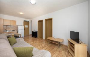 a living room with a couch and a tv at Apartment Vojskovo Croatia in Lokva Rogoznica