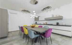 jadalnia ze stołem i kolorowymi krzesłami w obiekcie 5 Bedroom Amazing Home In Galizana w mieście Galižana